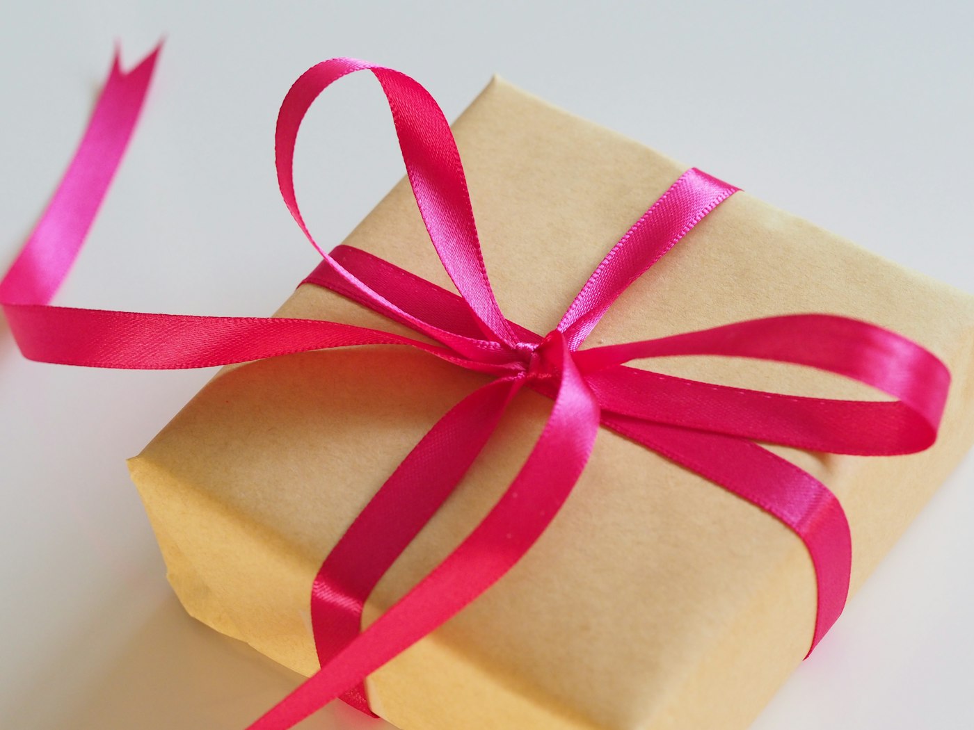 Boîte cadeau en papier kraft nouée d'un ruban rose vif