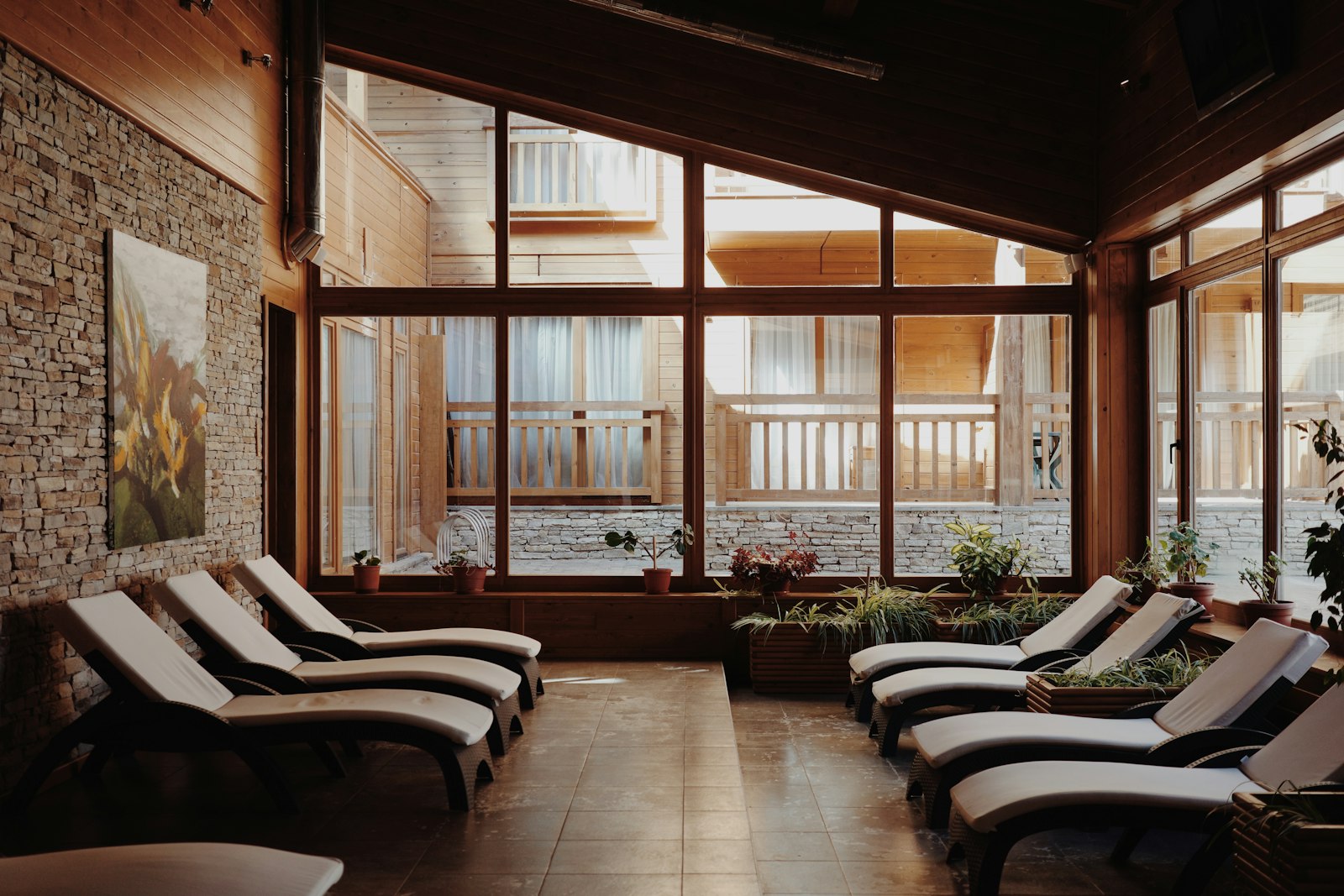 Salle de repos avec des fauteuils face à de grandes baies vitrées