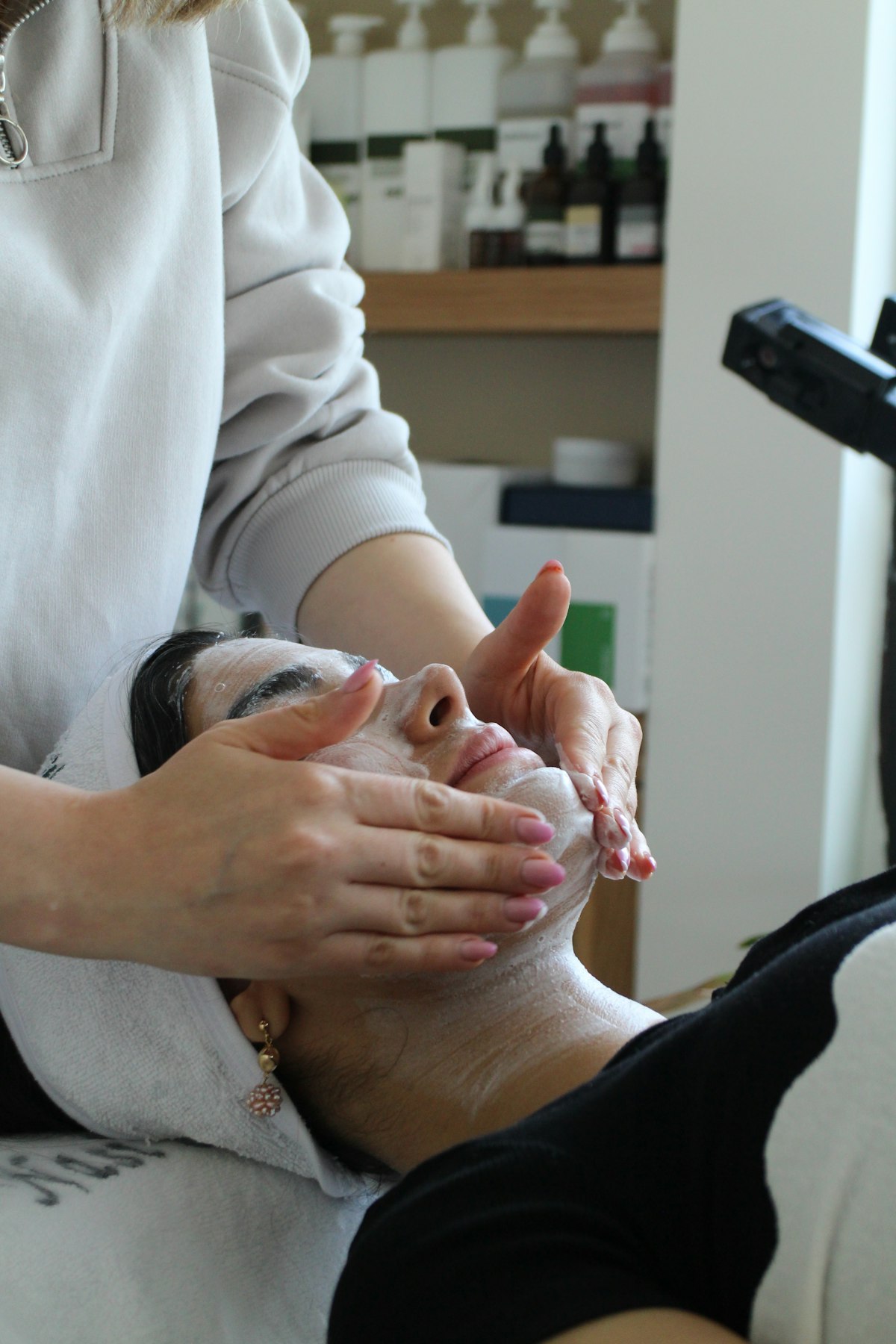 Mains d'une esthéticienne massant un visage
