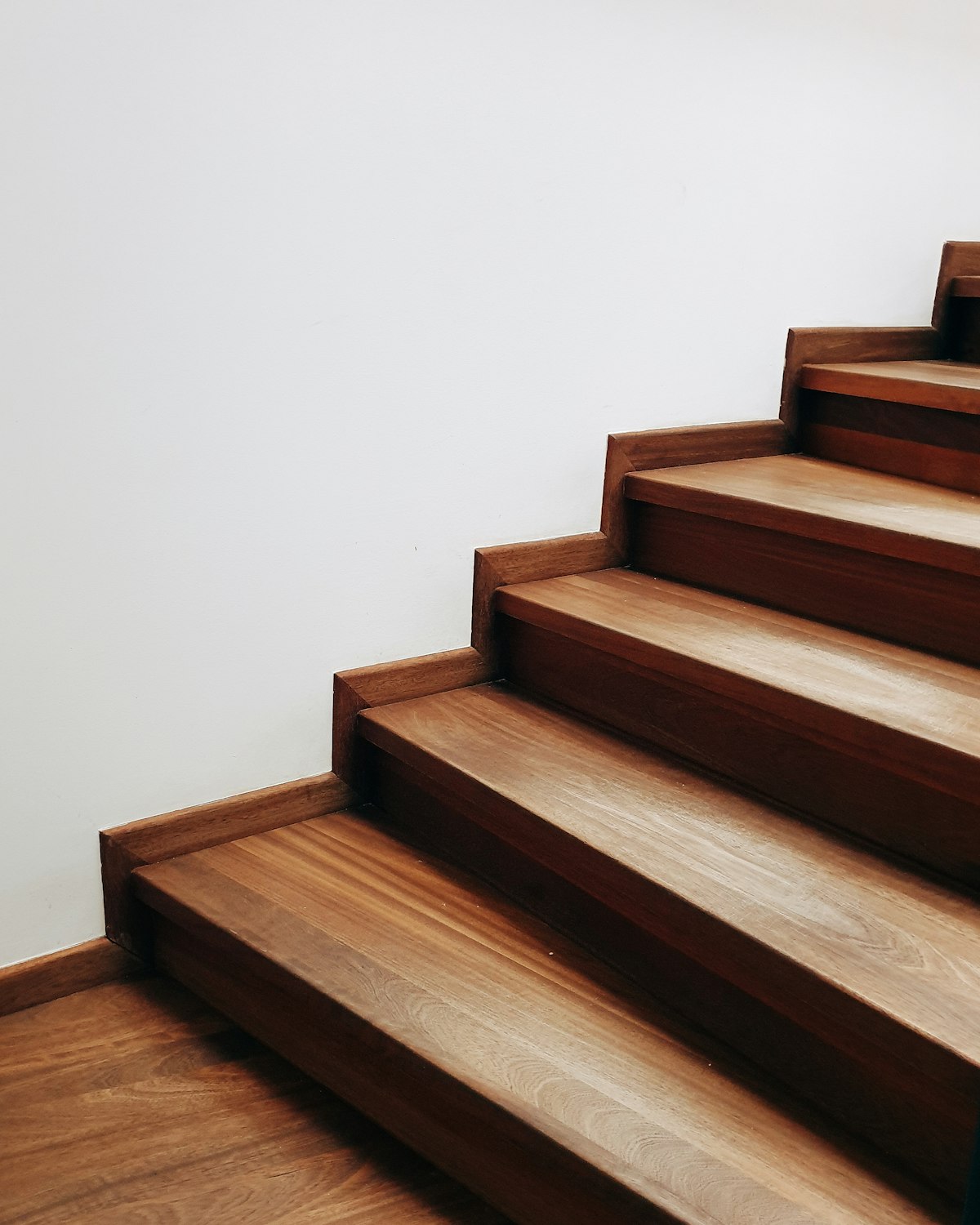 Escalier en bois aux marches épaisses le long d'un mur blanc